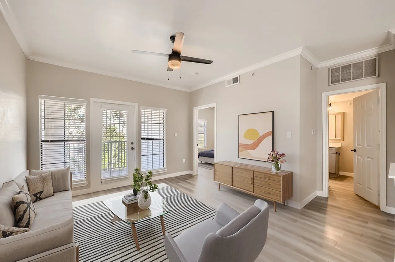 Living room, wood-style plank flooring, ceiling fan, glass doors, wood credenza