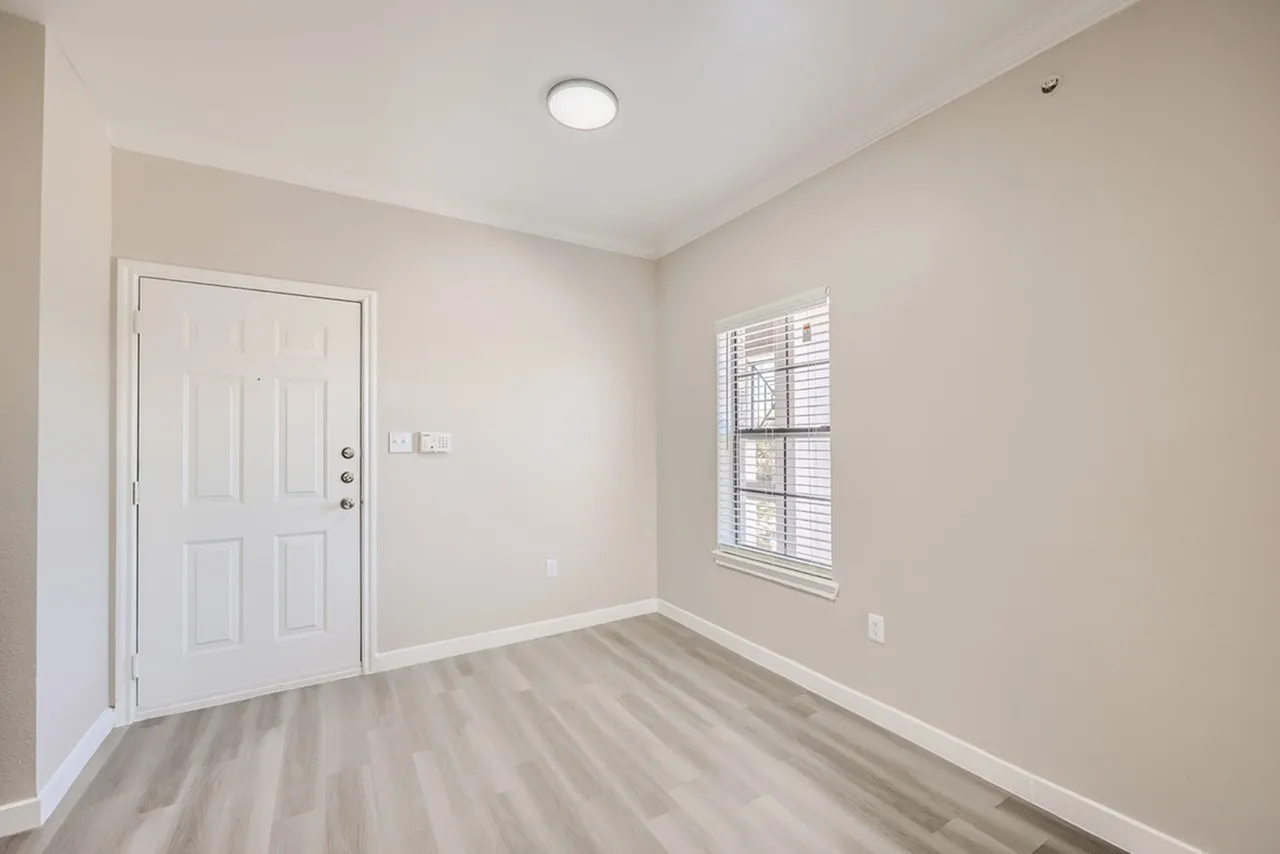 Entryway, white entry door, wood-style plank flooring, window with shutters, recessed ceiling light