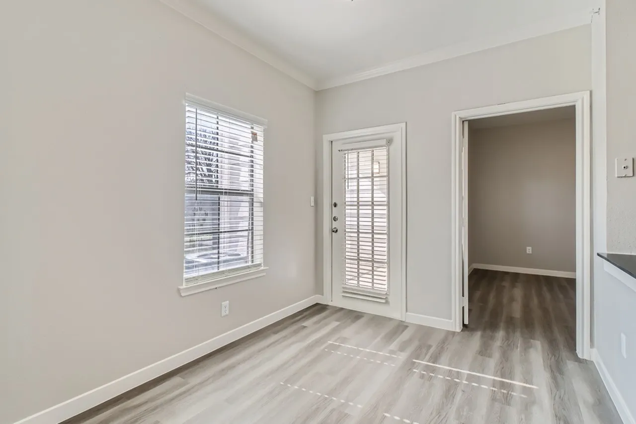 Entryway, wood-style plank flooring, shuttered glass door, large window, neutral walls