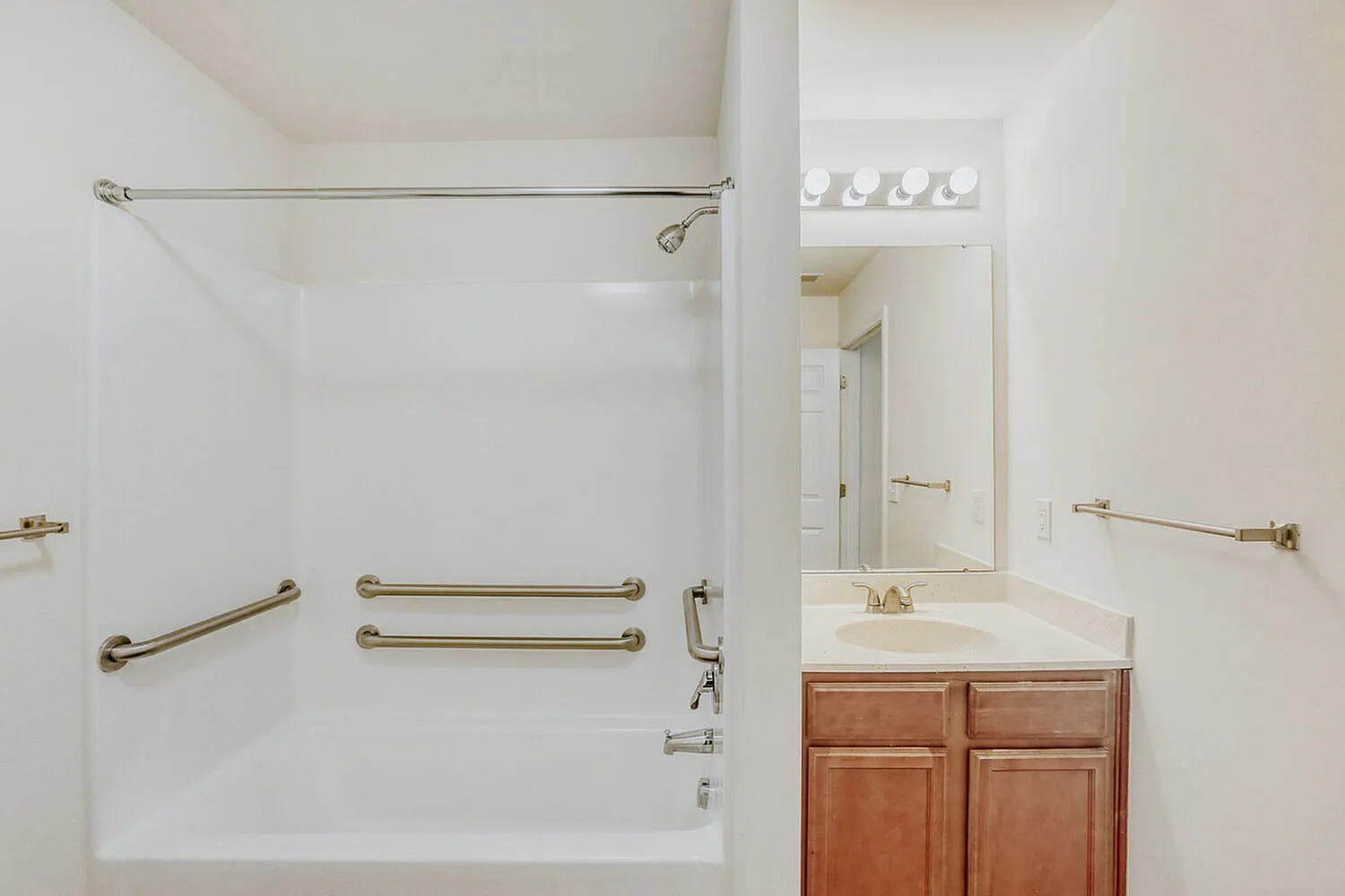 Bathroom, wooden vanity cabinetry, white countertop, framed mirror, chrome hardware and fixtures