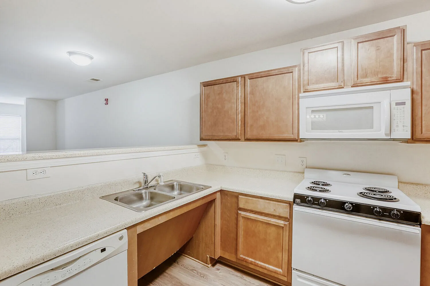 Kitchen, wood cabinetry, laminate countertops, white appliances, sink