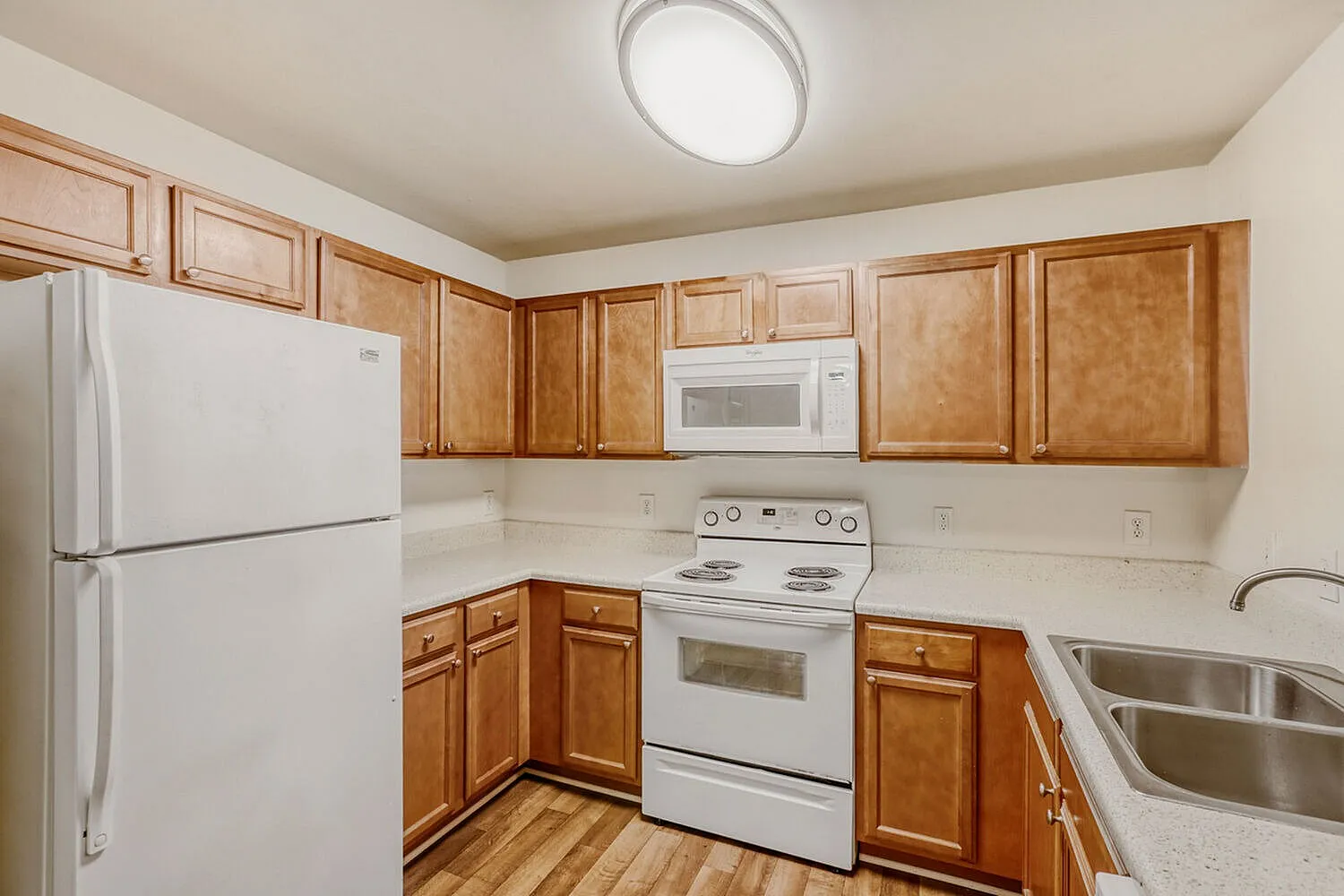 Kitchen, wood cabinetry, white appliances, wood-style plank flooring, recessed lighting