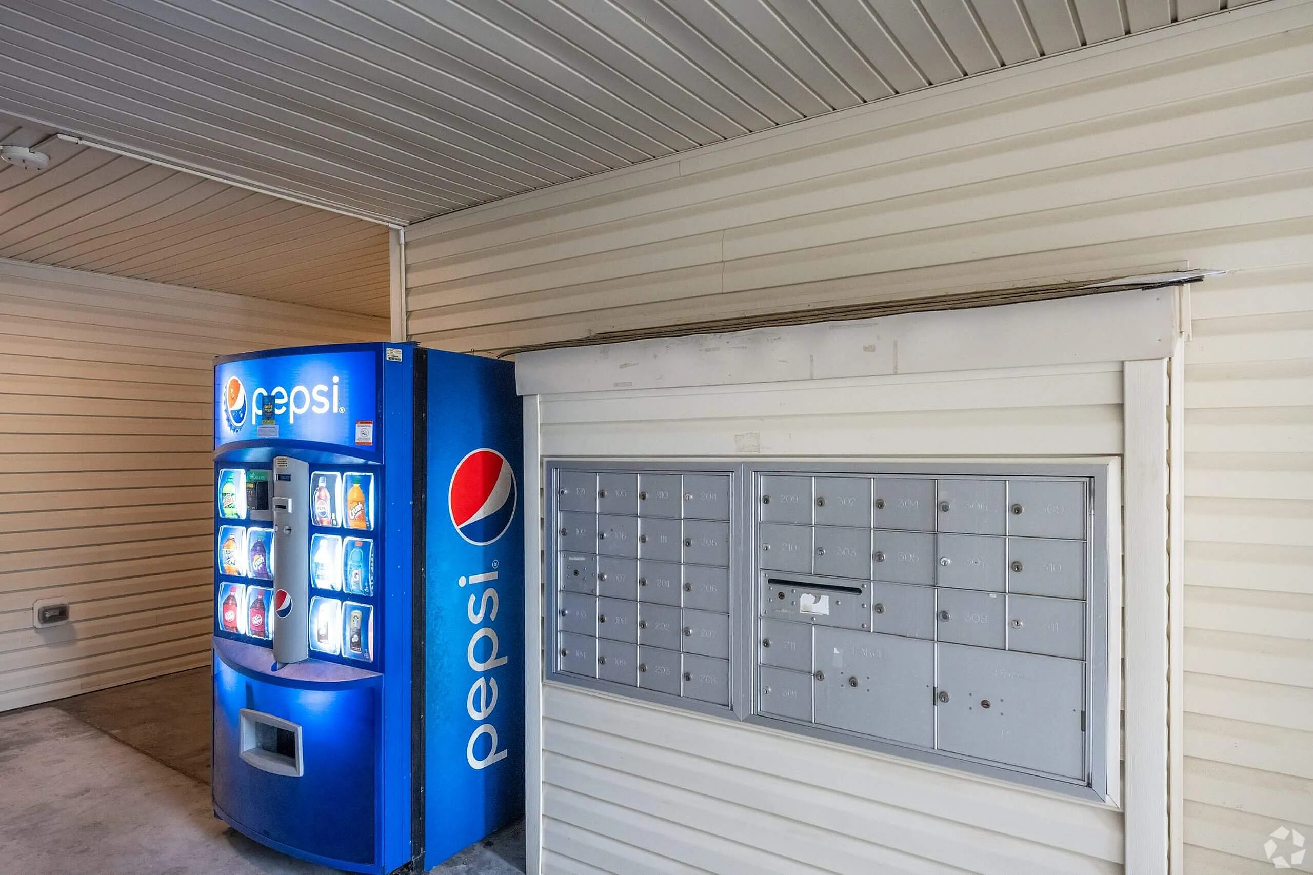 Amenity room with blue Pepsi vending machine, mailbox panel, metal ceiling, corrugated siding