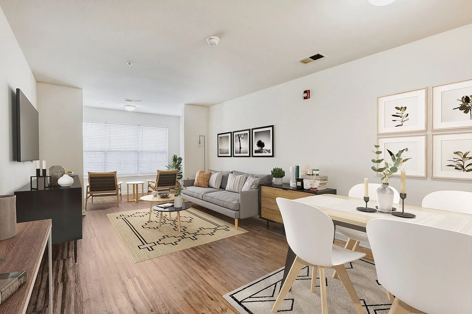 Open-concept living space, wood-style plank flooring, contemporary furnishings, botanical artwork