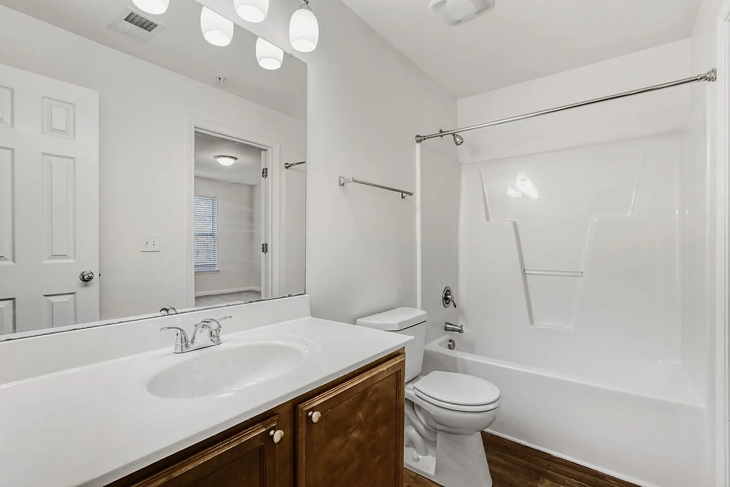 Bathroom, wood-style vanity cabinetry, quartz countertop, recessed lighting, glass shower enclosure