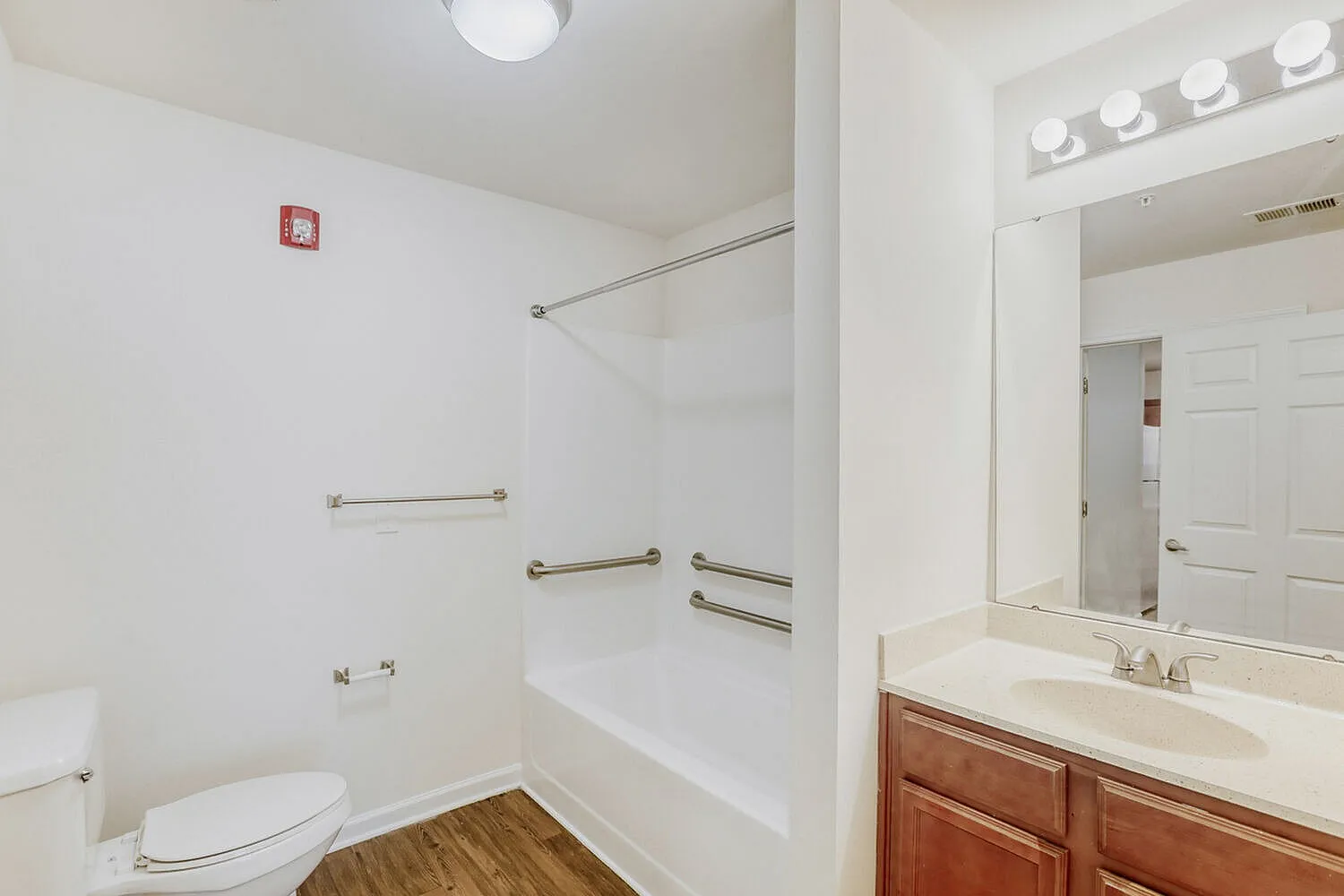 Bathroom, wood vanity cabinet, white countertop, large mirror, chrome fixtures
