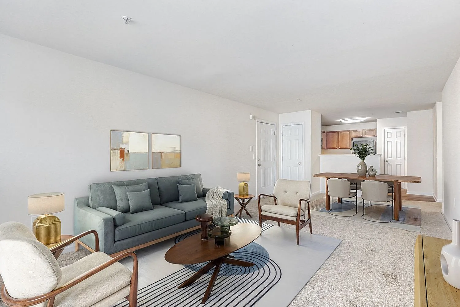 Living room with gray sofa, wood-style plank flooring, dining table, cream armchairs