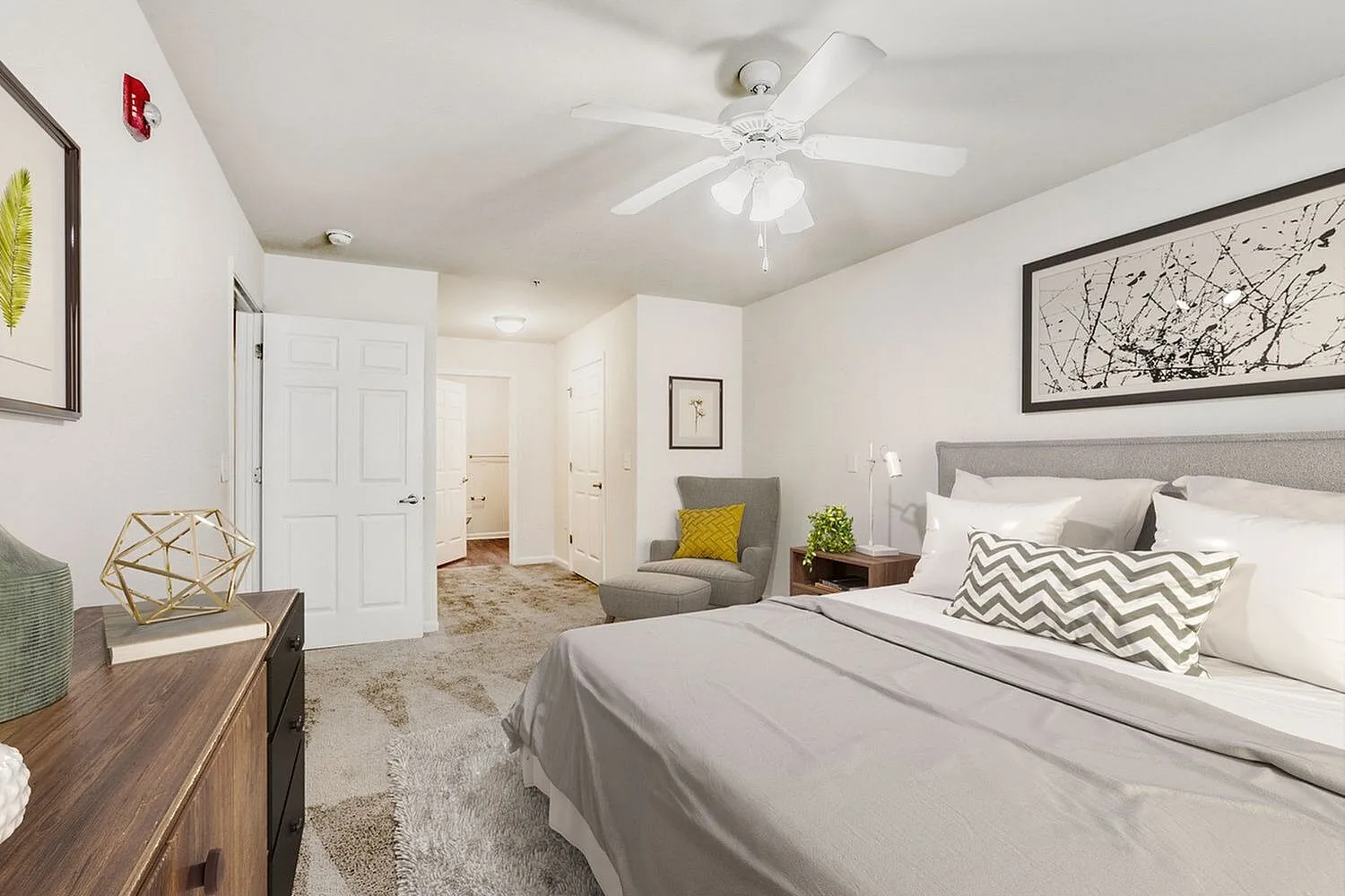 Primary bedroom, wood-style plank flooring, gray upholstered headboard, ceiling fan