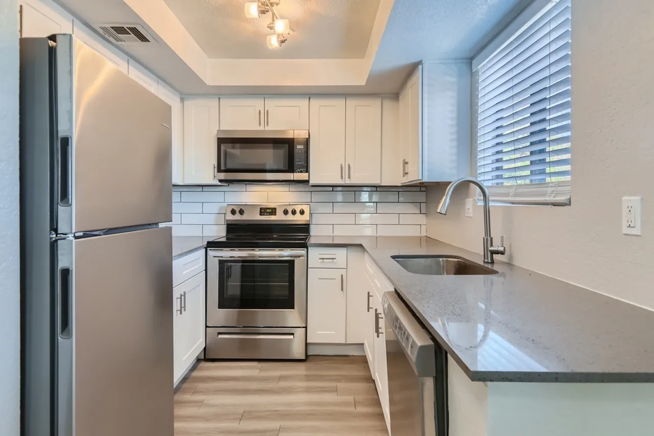 Kitchen, white shaker cabinetry, quartz countertops, stainless steel appliances, subway tile backsplash, wood-style plank flooring