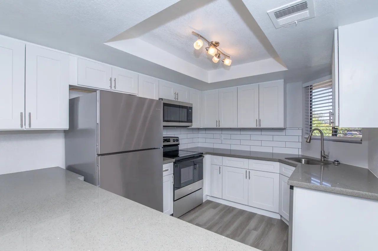 Kitchen, white shaker cabinetry, gray quartz countertops, stainless appliances, white subway tile backsplash