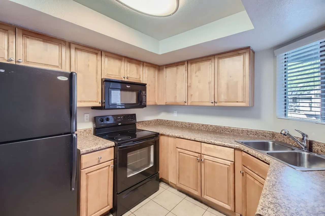 Kitchen, light wood cabinetry, granite countertops, black appliances, tile flooring
