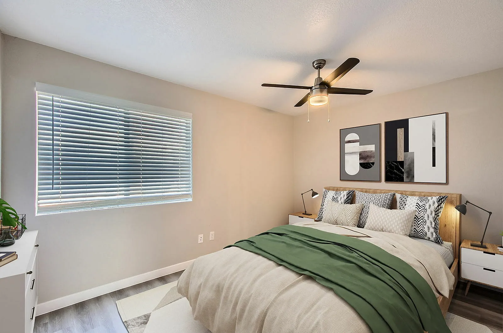 Primary bedroom, wood-style plank flooring, ceiling fan with light fixture, white nightstands