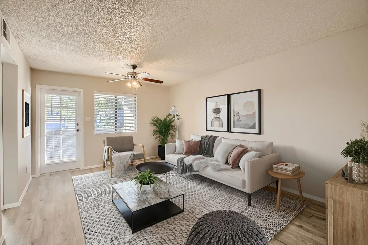 Living room, wood-style plank flooring, gray upholstered sofa, ceiling fan, glass doors