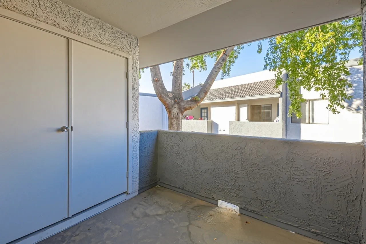 Covered patio area, concrete flooring, built-in storage cabinet, tree views