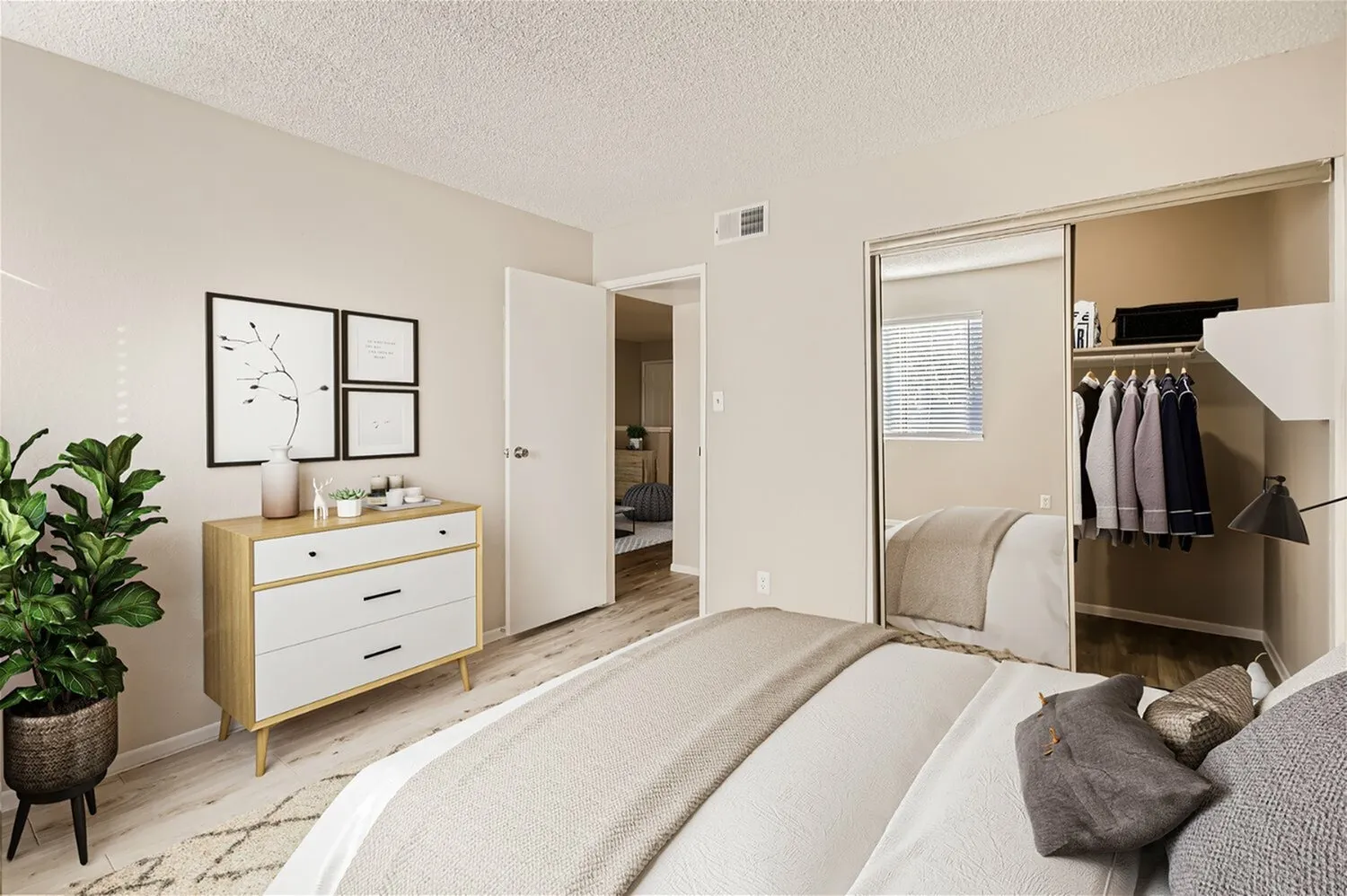 Primary bedroom, wood-style plank flooring, mirrored closet doors, wood dresser