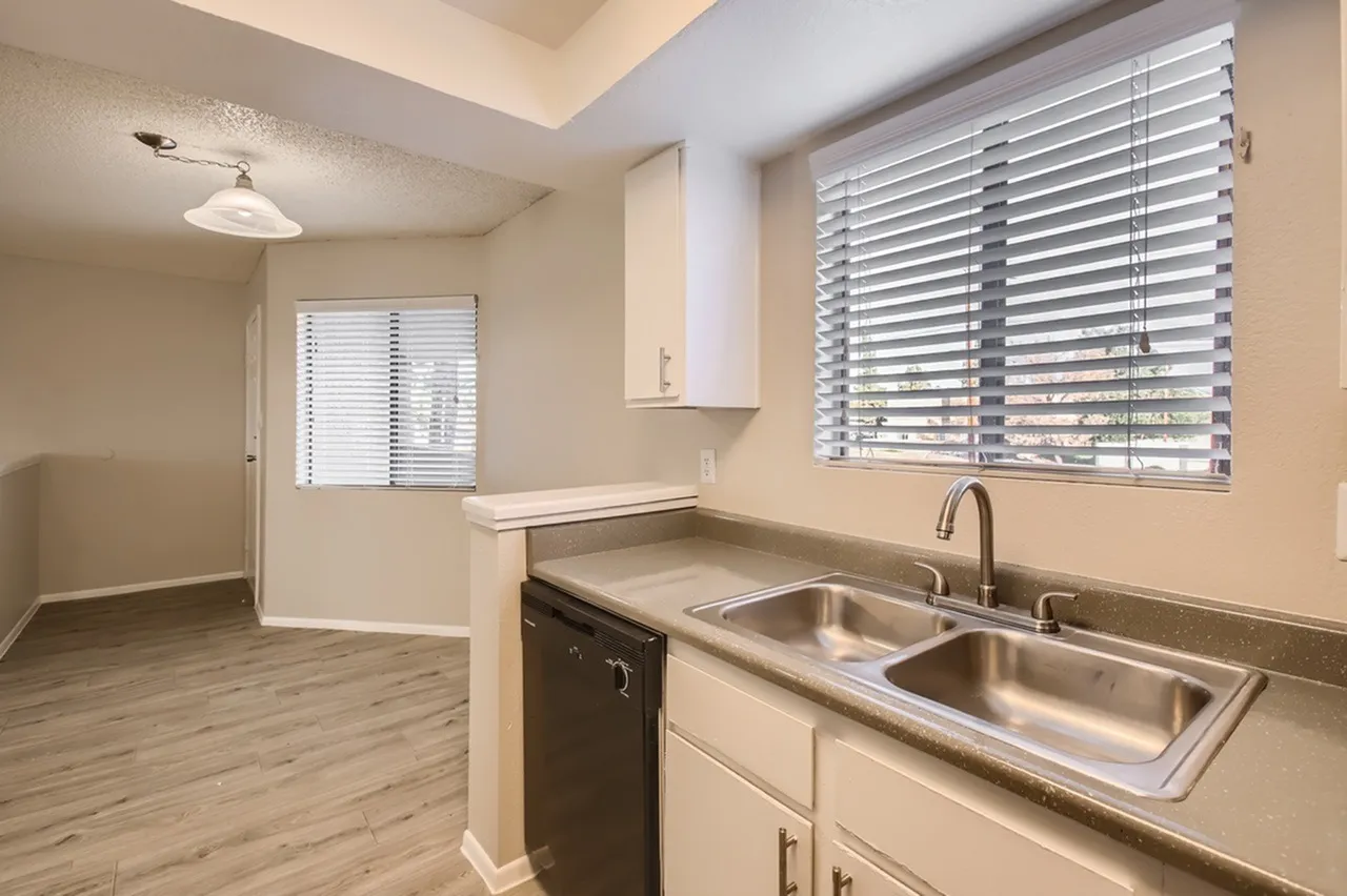 Kitchen, dark cabinetry, stainless double sink, wood-style plank flooring, blinds