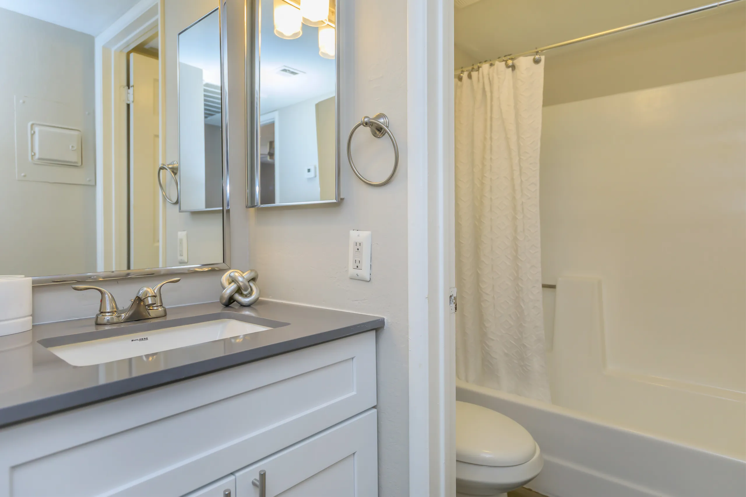 Bathroom with vanity sink, mirror, and tub/shower combo