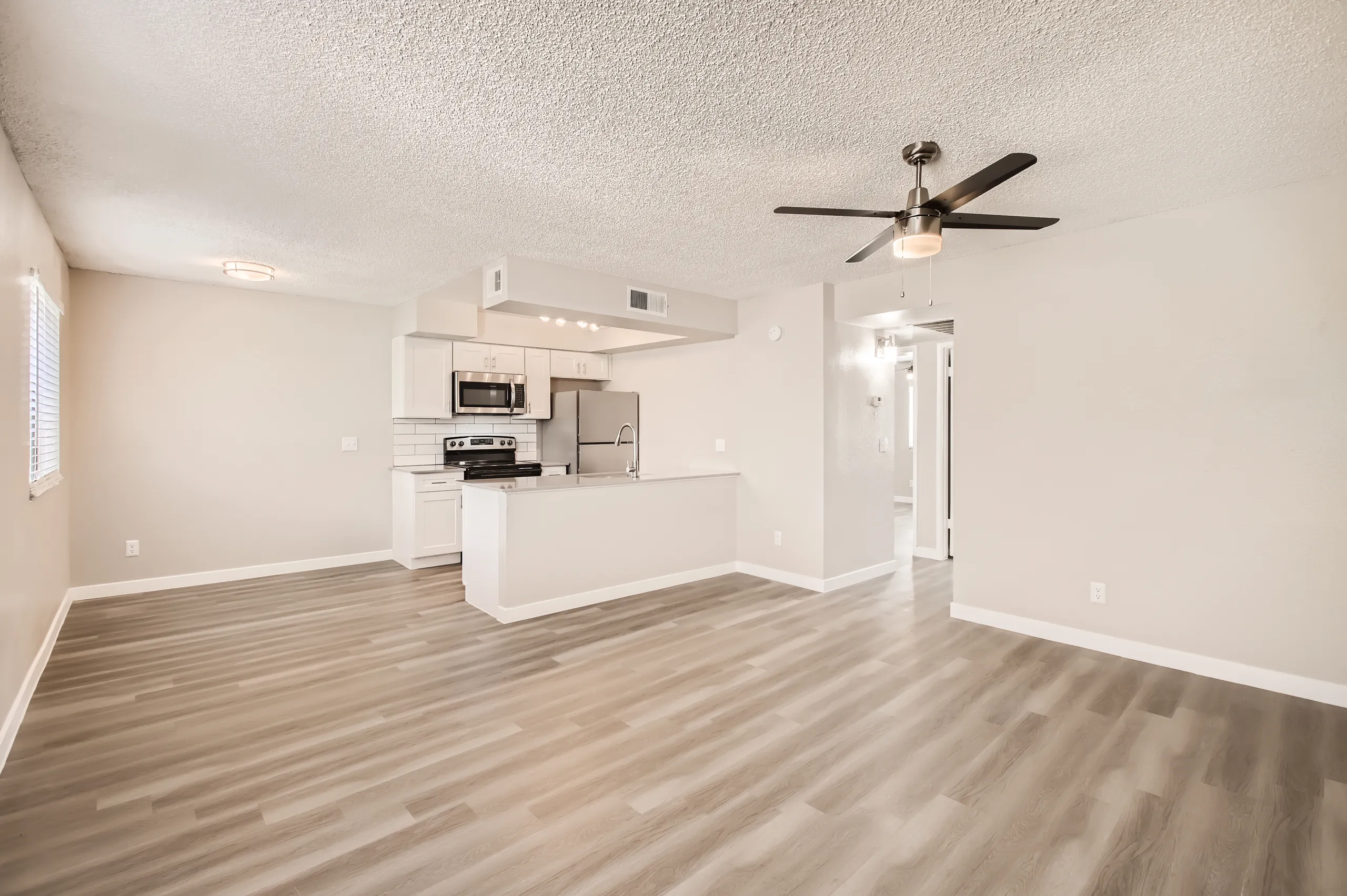 Living room opening into kitchen with stainless appliances