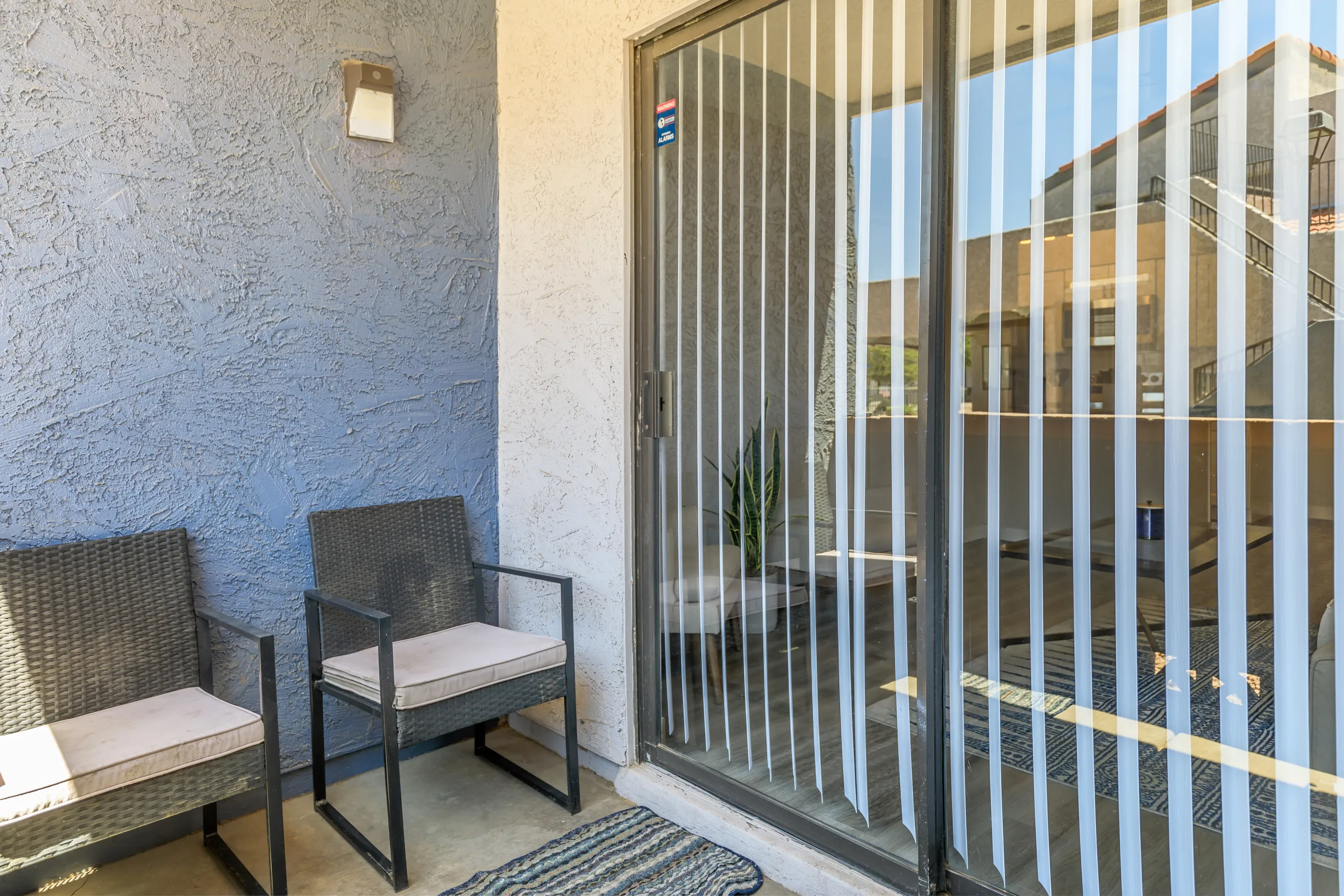 Private patio with seating and sliding glass door entry