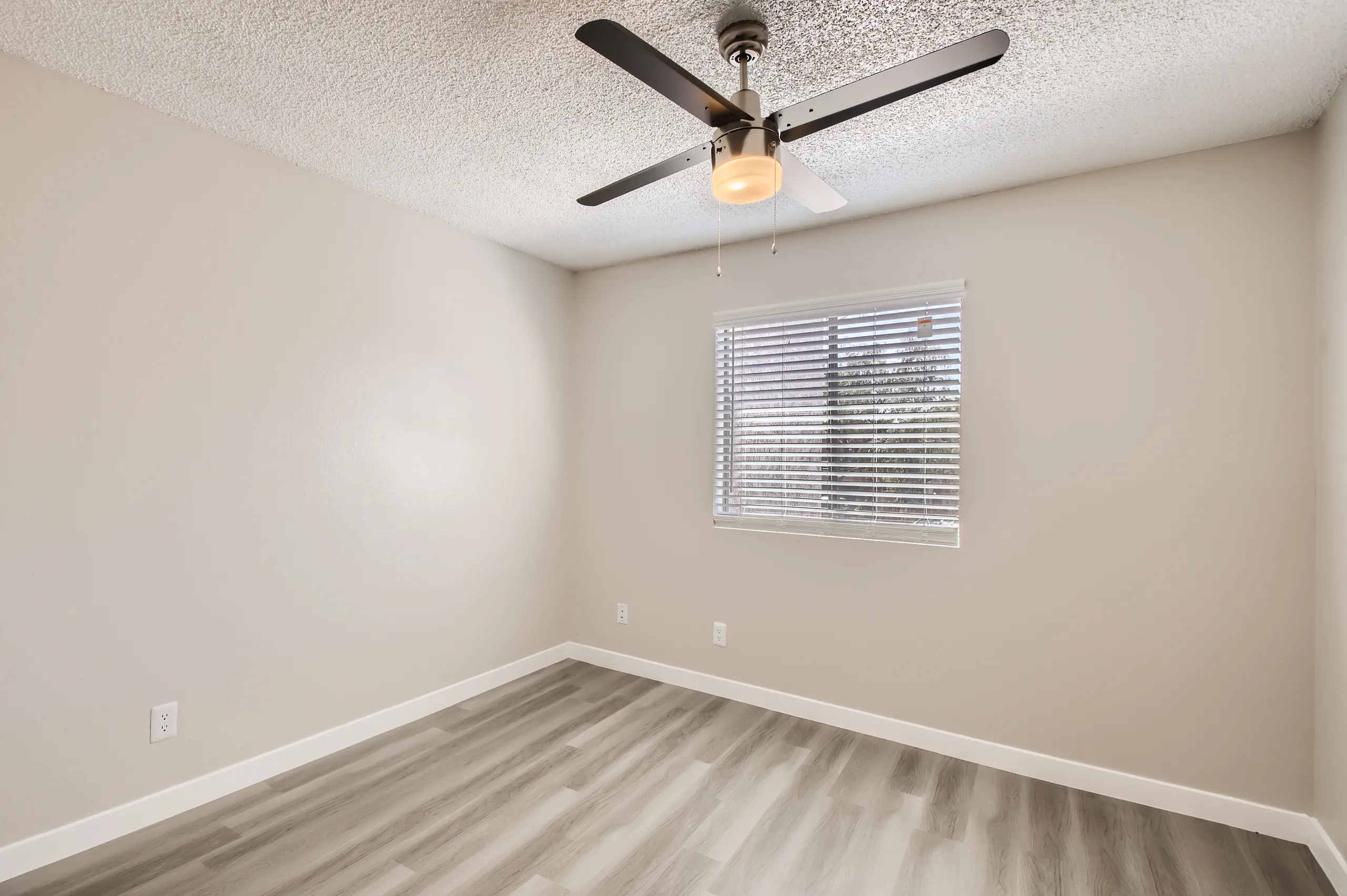Secondary bedroom with ceiling fan and wood-style flooring