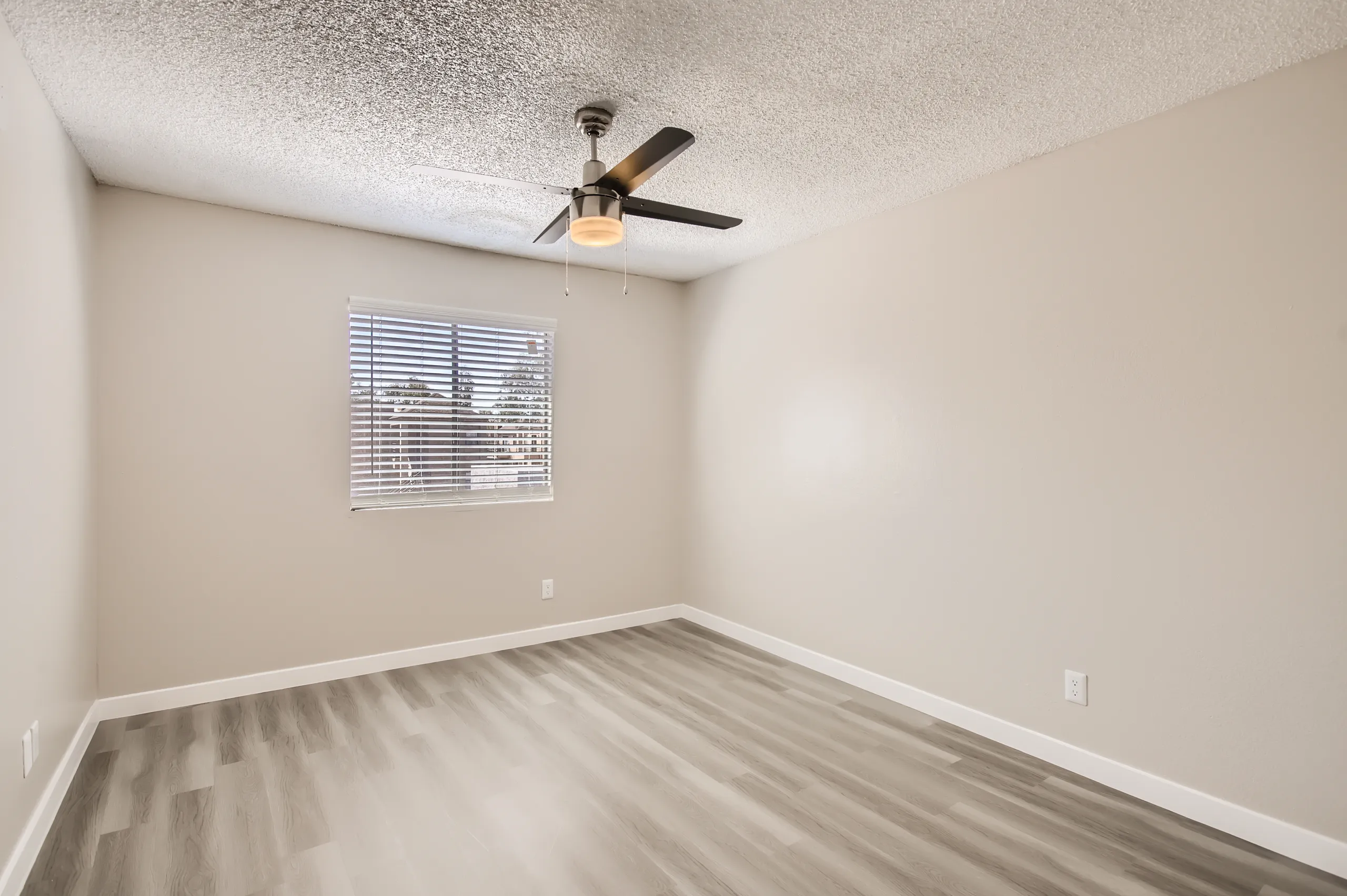 B1 Platinum floor plan primary bedroom with ceiling fan and wood-style flooring