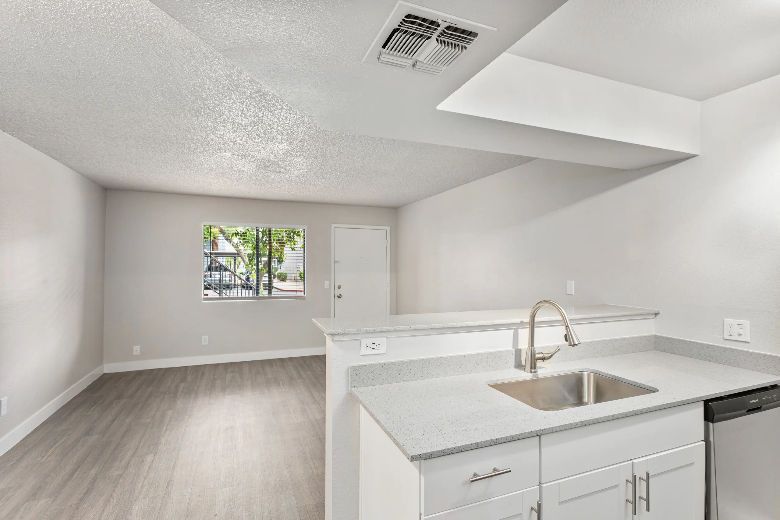 Kitchen sink area with quartz counters opening to living space