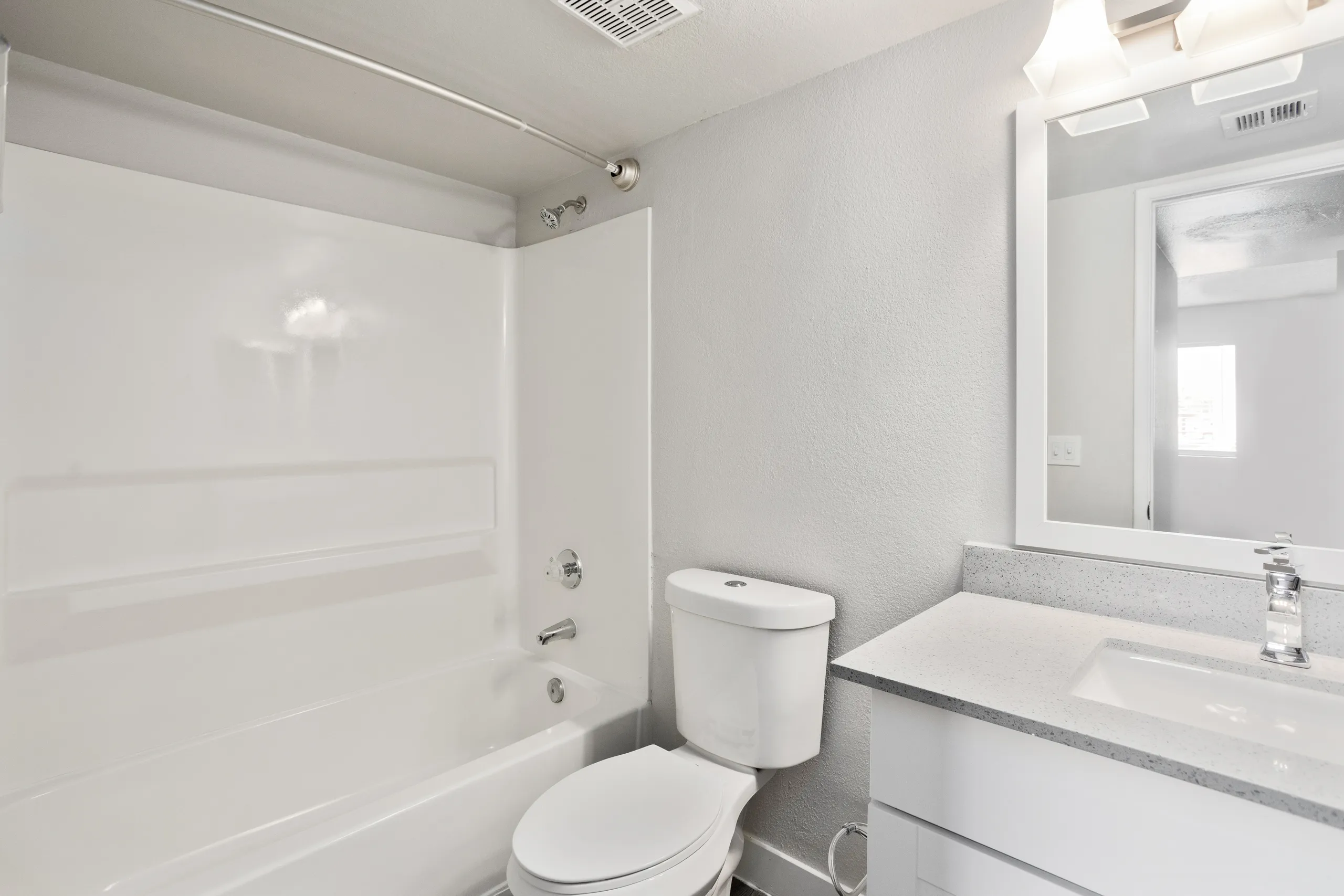 Ensuite bathroom with vanity, mirror, and tub/shower combo