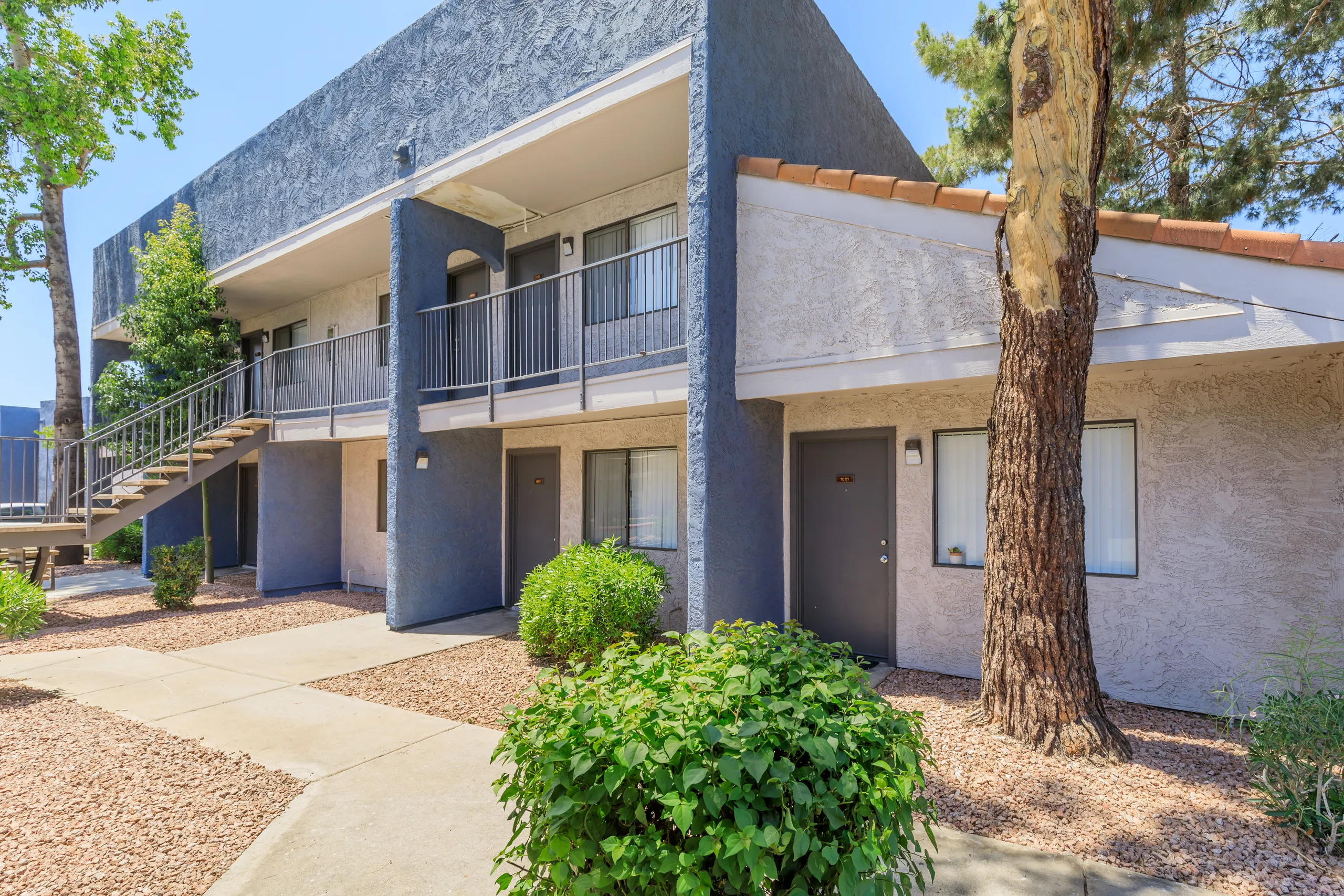 Two-story building exterior with staircase and landscaped walkway