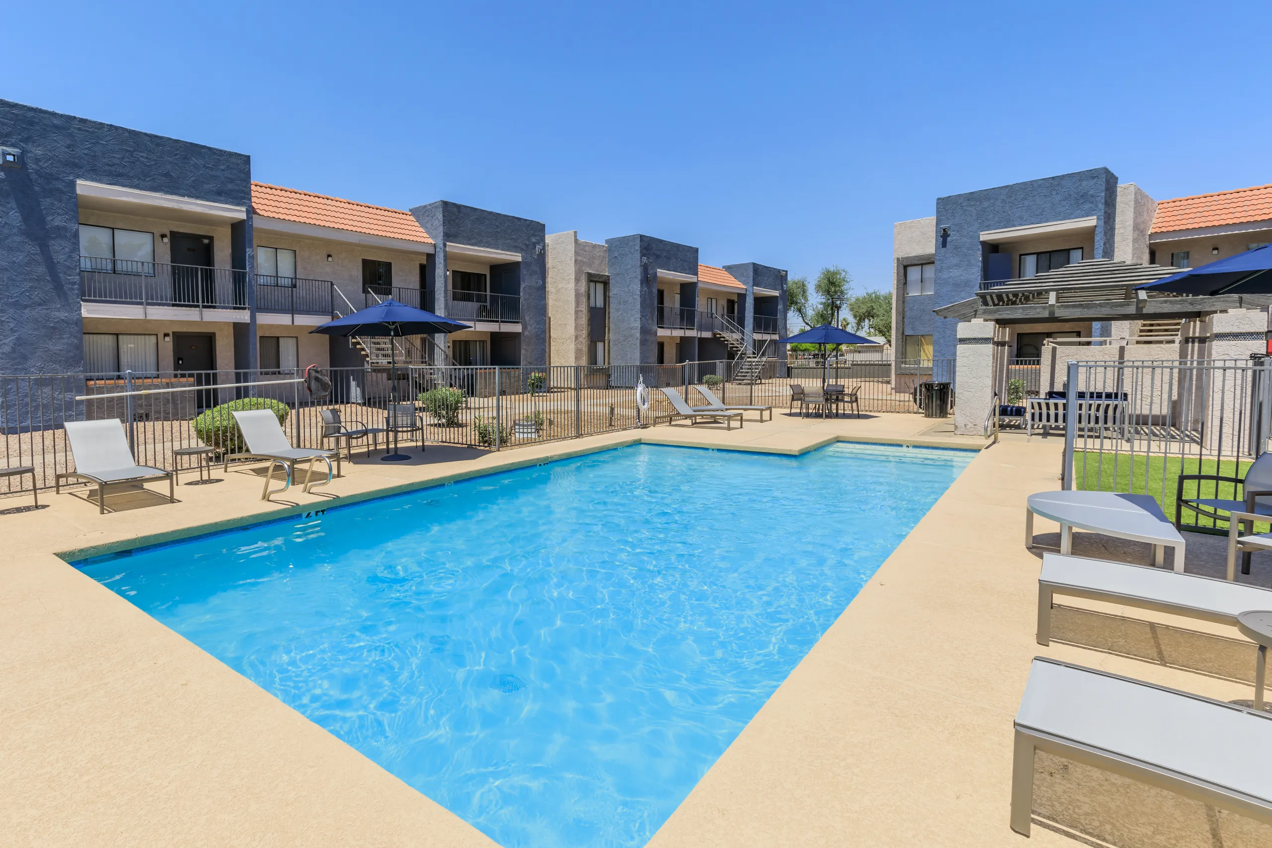 Wide view of pool area with patio furniture and surrounding buildings