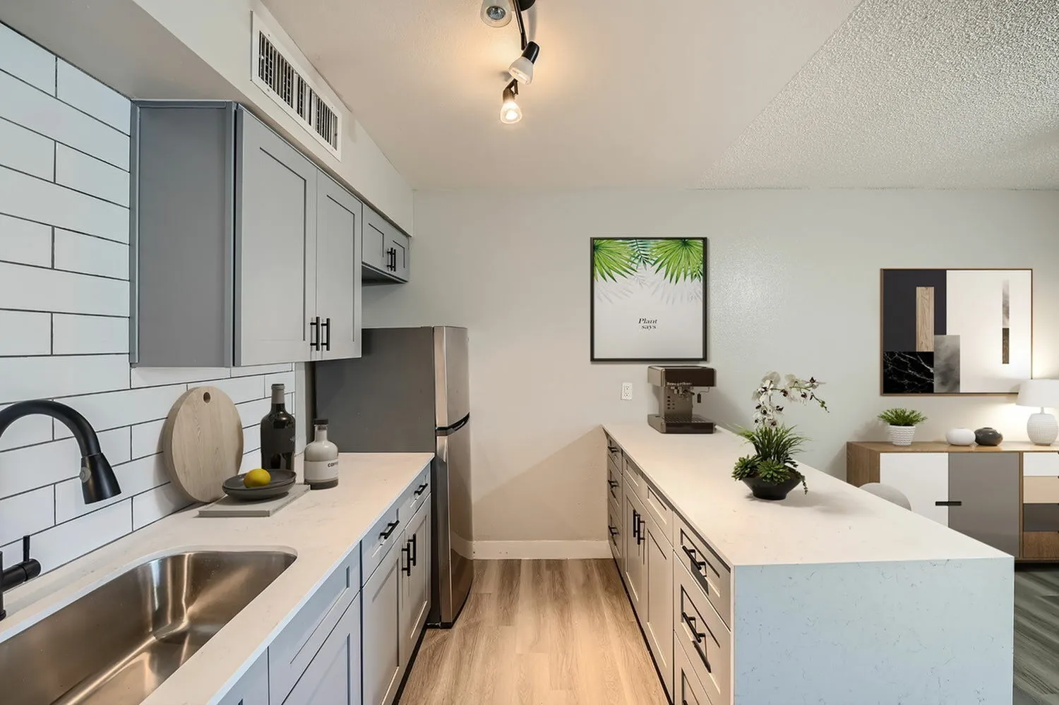 Kitchen, white shaker cabinetry, quartz countertops, stainless appliances, wood-style plank flooring