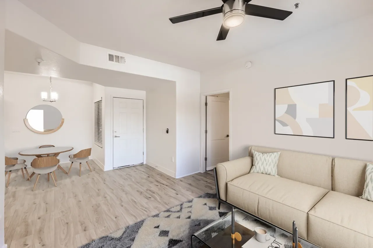 Living room with wood-style plank flooring, cream sofa, ceiling fan, geometric area rug