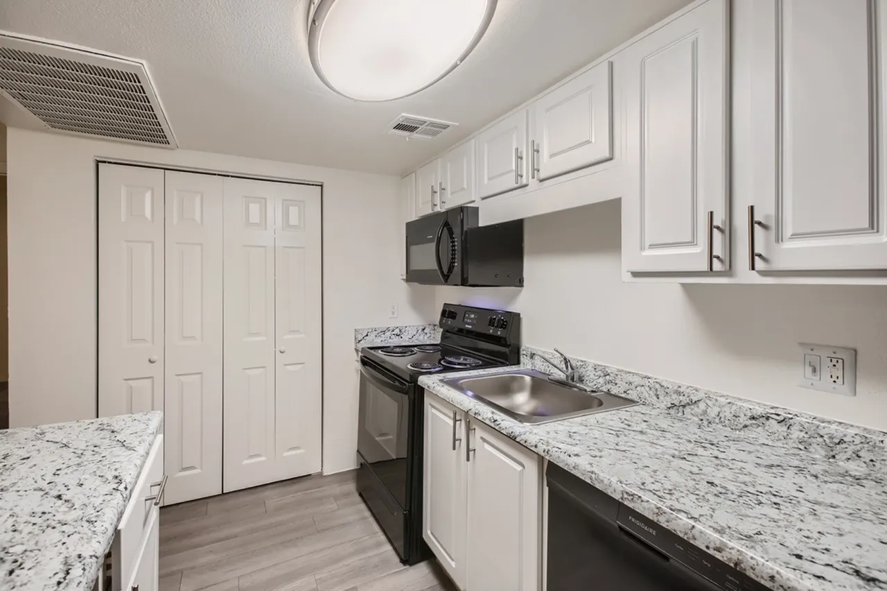 Kitchen, white shaker cabinetry, granite countertops, stainless appliances, wood-style plank flooring