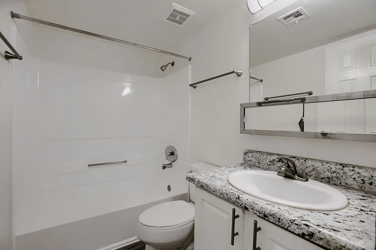 Bathroom, granite countertop, white oval sink, chrome fixtures, mirror