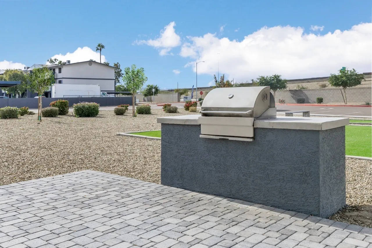 Community outdoor kitchen, stainless steel grill, concrete countertop, paver patio
