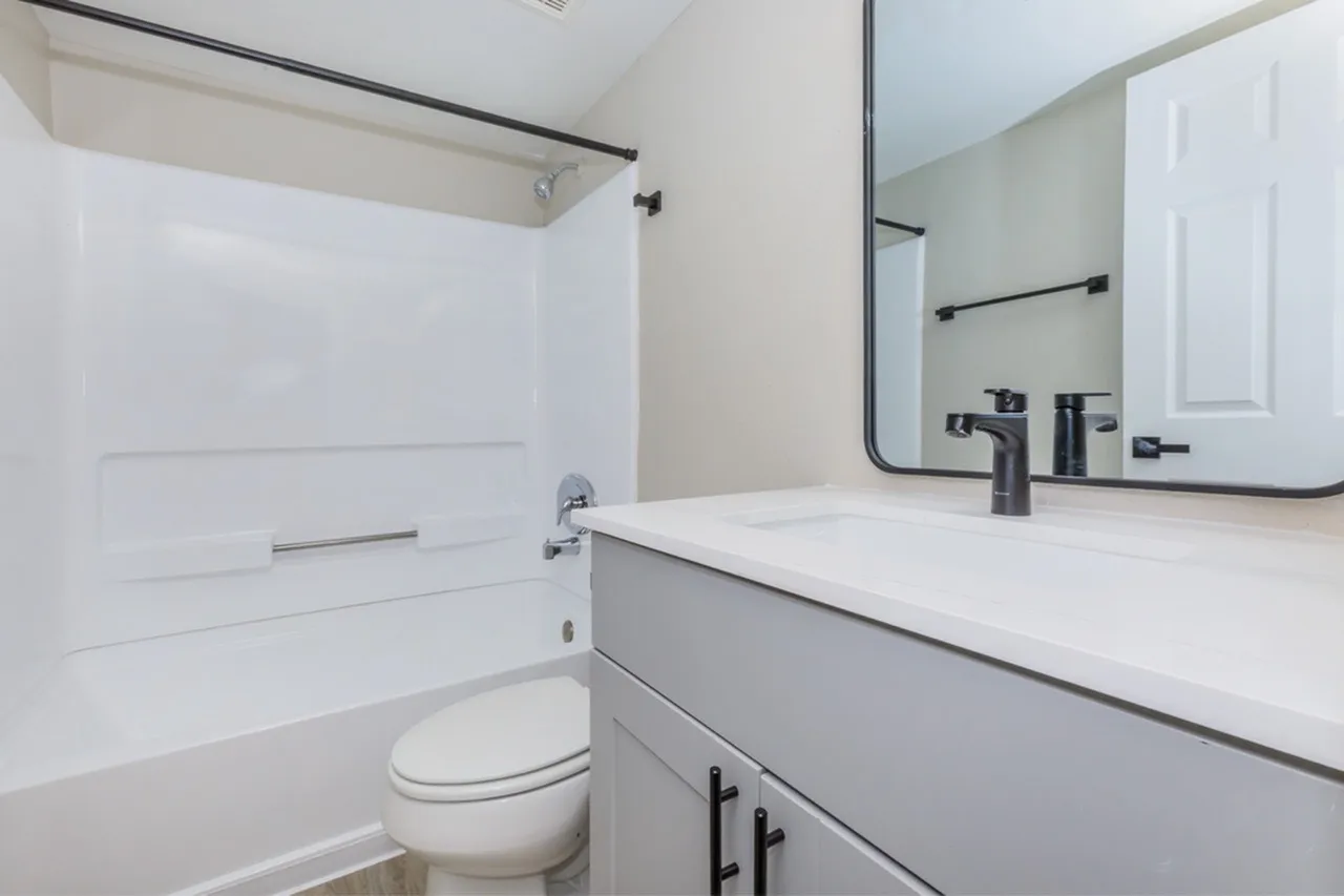 Bathroom, white cabinetry, quartz countertops, black faucet and fixtures