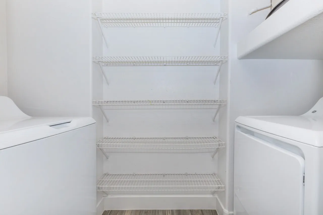 Refrigerator interior, wire shelving, white appliances, laundry room