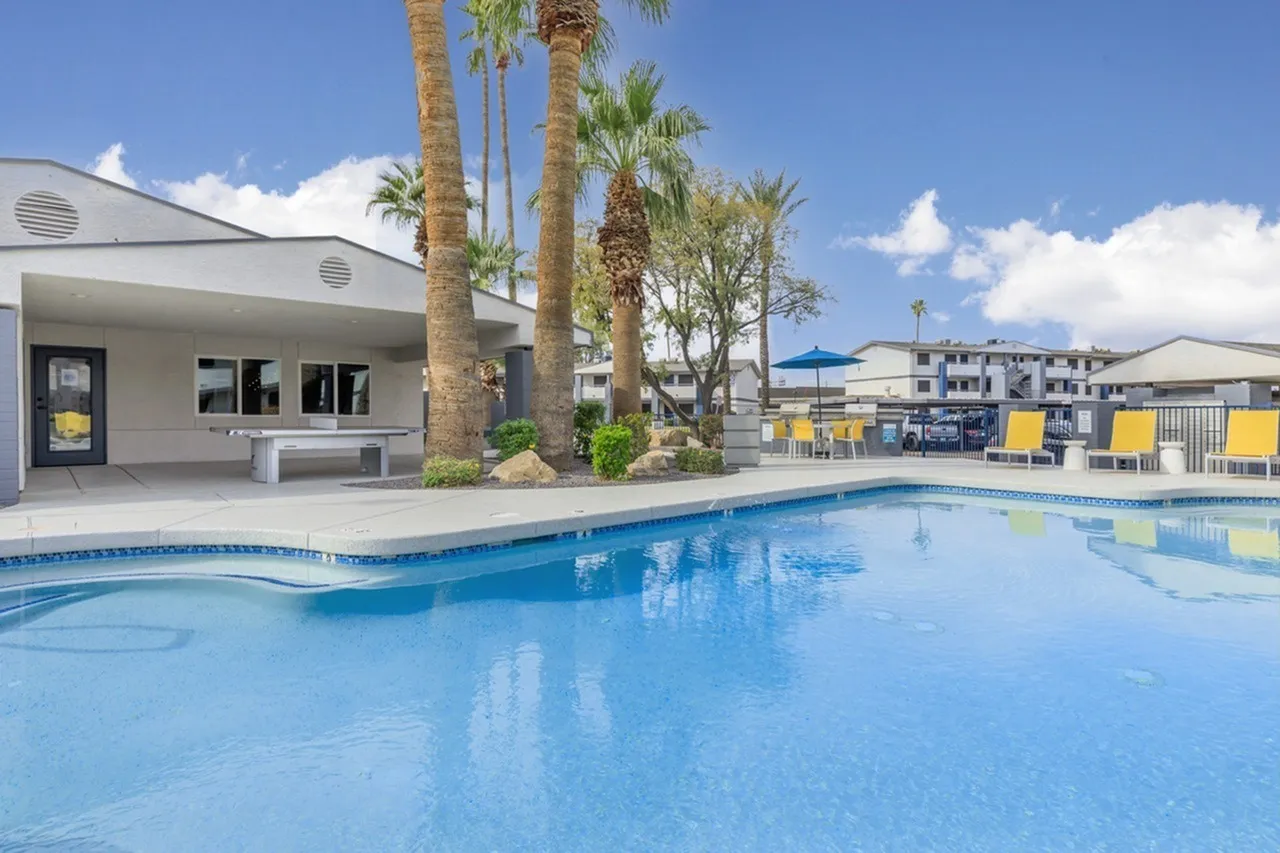 Swimming pool, white pool house, palm trees, yellow lounge chairs, blue umbrella, Phoenix