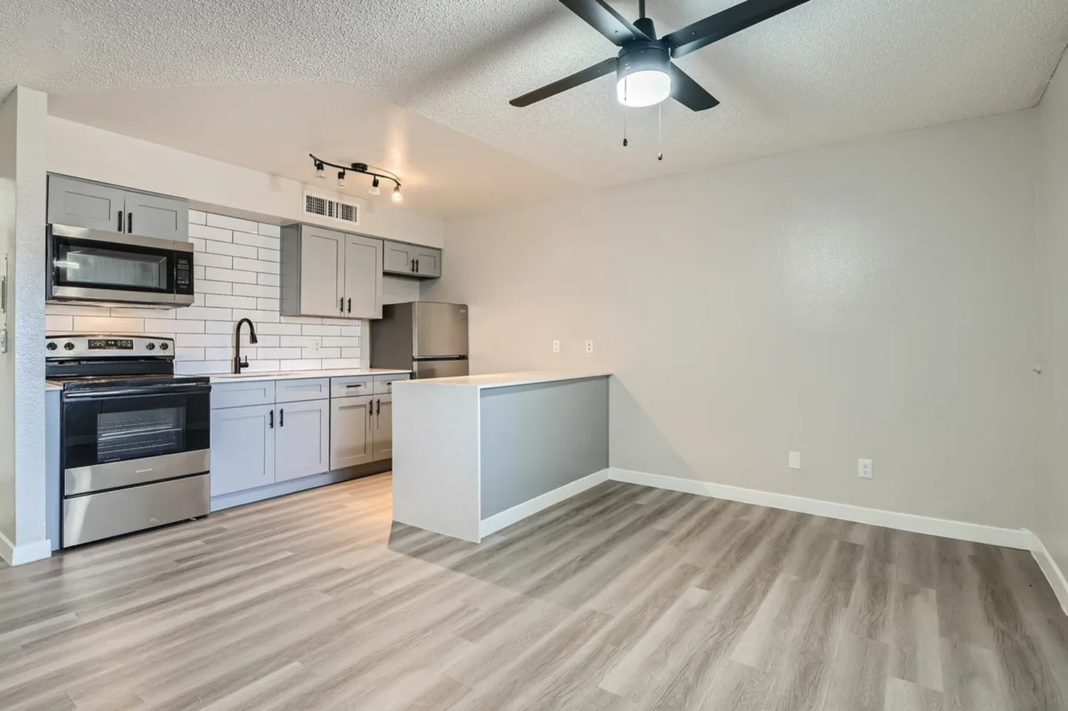 Kitchen, white shaker cabinetry, stainless steel appliances, white subway tile backsplash, wood-style plank flooring, ceiling fan