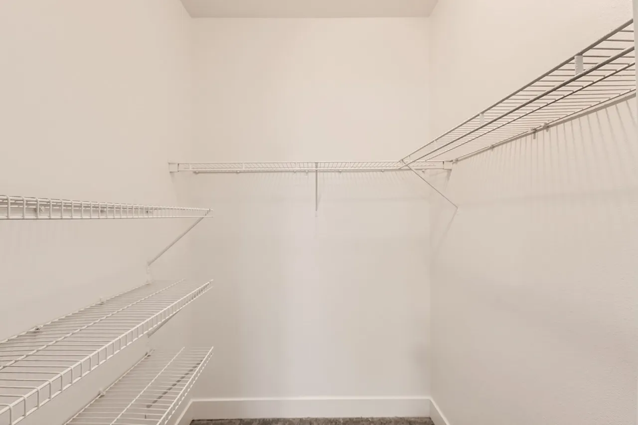 Walk-in closet, metal wire shelving systems, multiple shelves, white walls