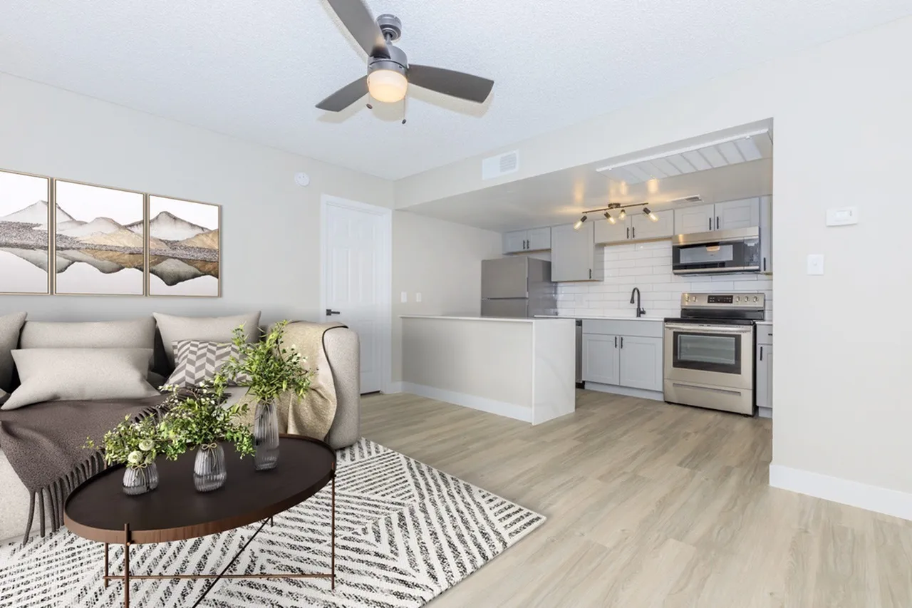 Living room and kitchen, wood-style plank flooring, stainless appliances, ceiling fan