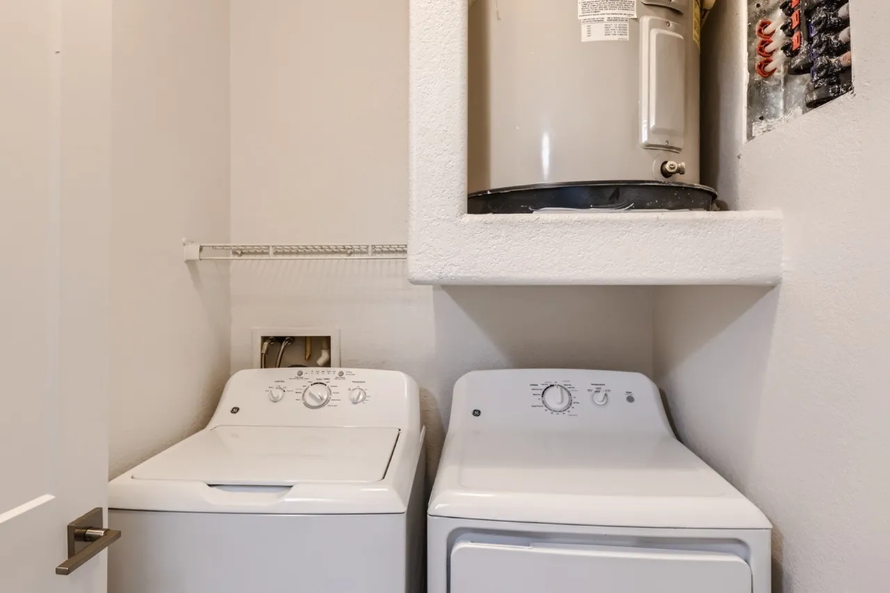 Laundry room, white washer and dryer, built-in shelving, water heater