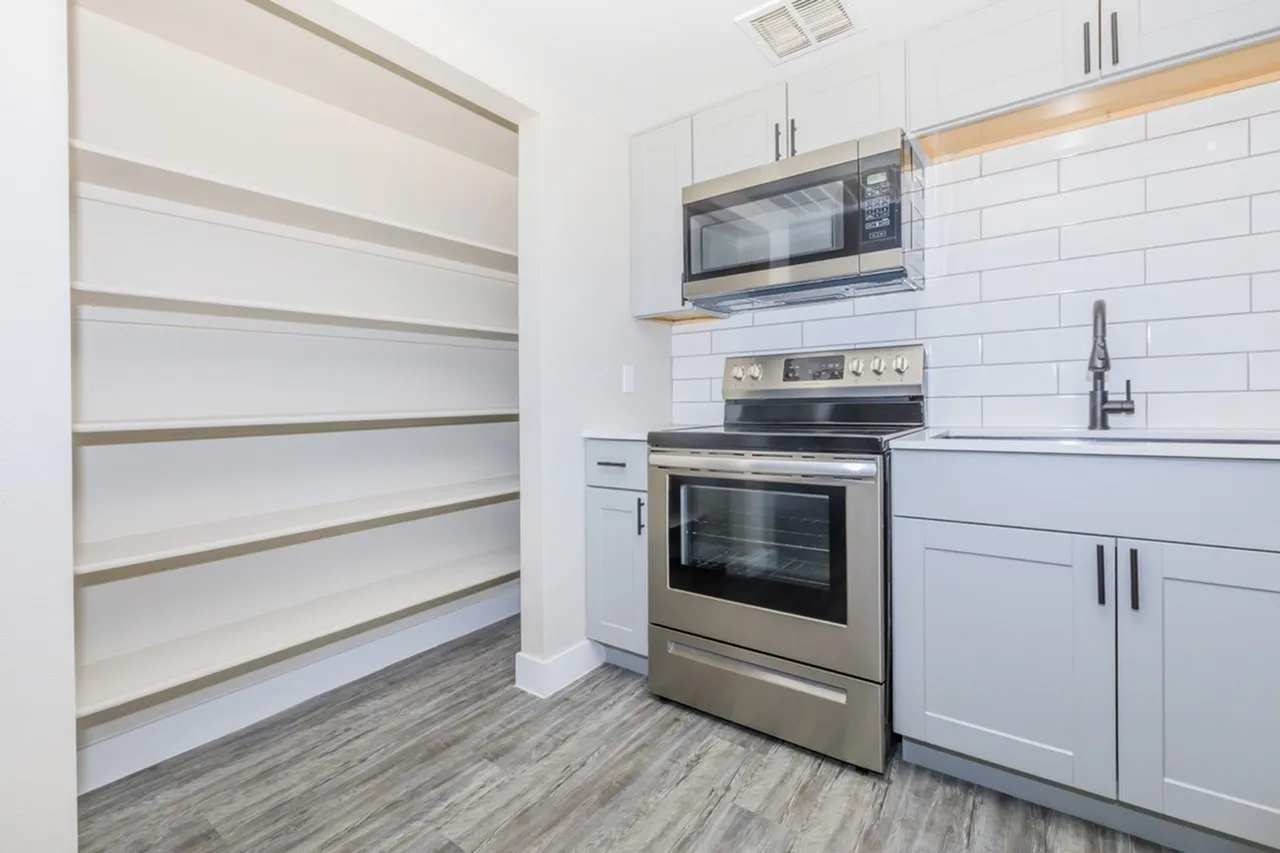 Kitchen, white shaker cabinetry, subway tile backsplash, stainless steel appliances, wood-style plank flooring