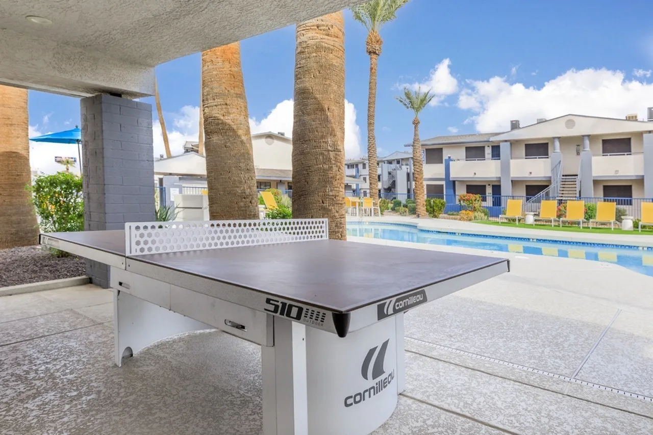 Outdoor ping pong table, palm trees, swimming pool, residential buildings