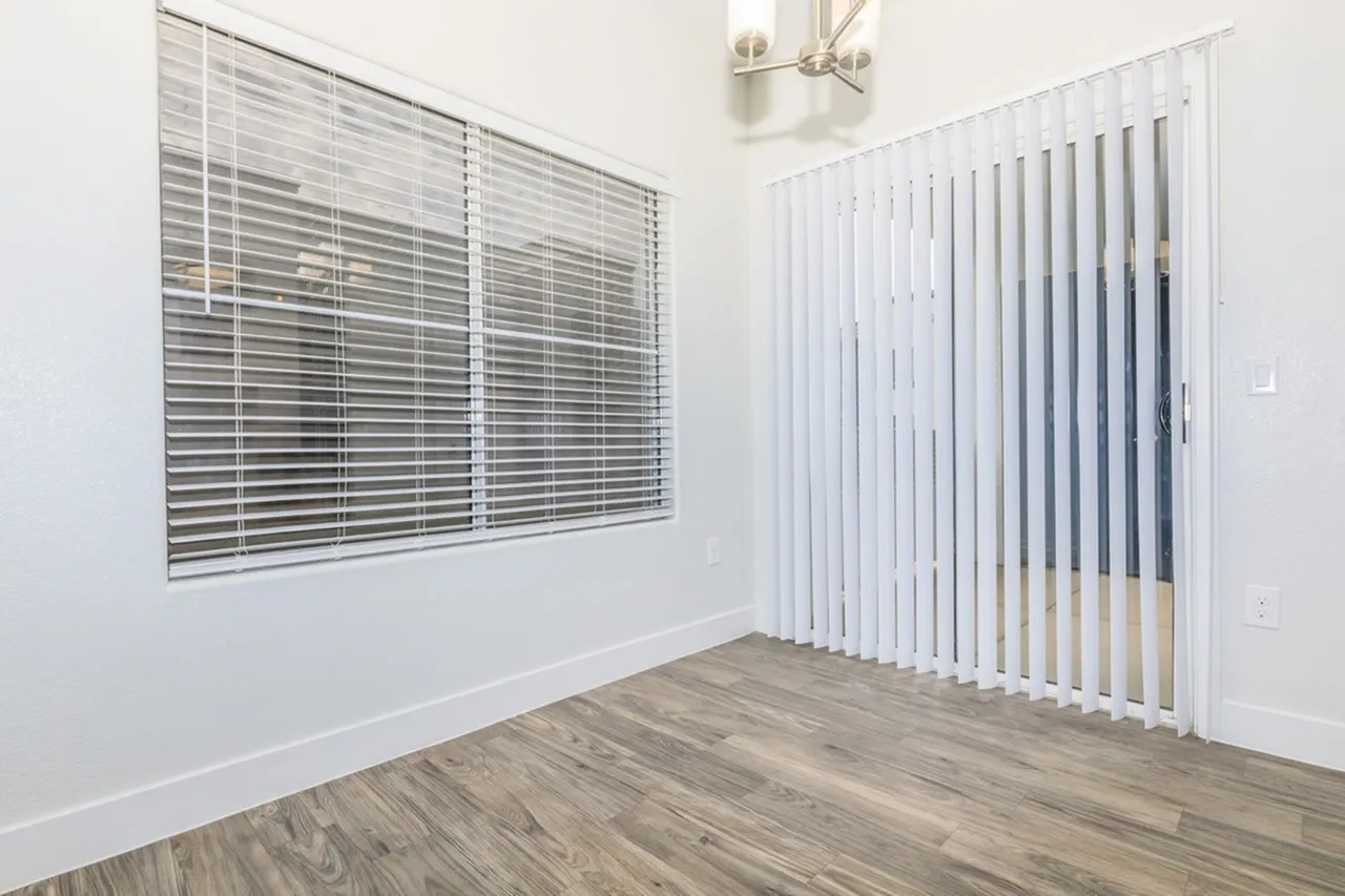 Bedroom, vertical blinds, wood-style plank flooring, white walls, ceiling fan