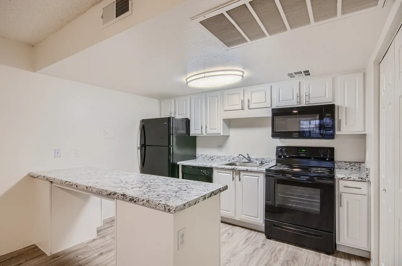 Kitchen, white shaker cabinetry, granite countertops, black appliances, wood-style plank flooring