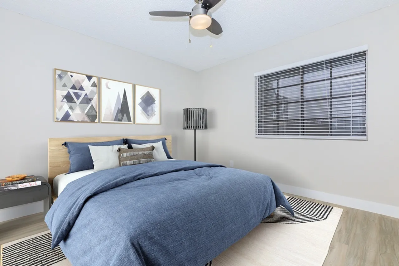 Primary bedroom, wood-style plank flooring, ceiling fan with light, geometric wall art