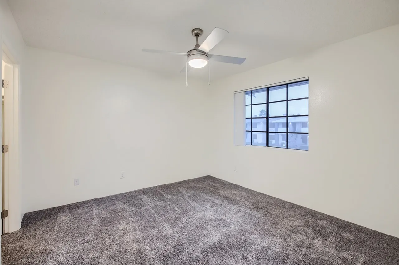 Bedroom, gray carpet flooring, ceiling fan with light, grid window