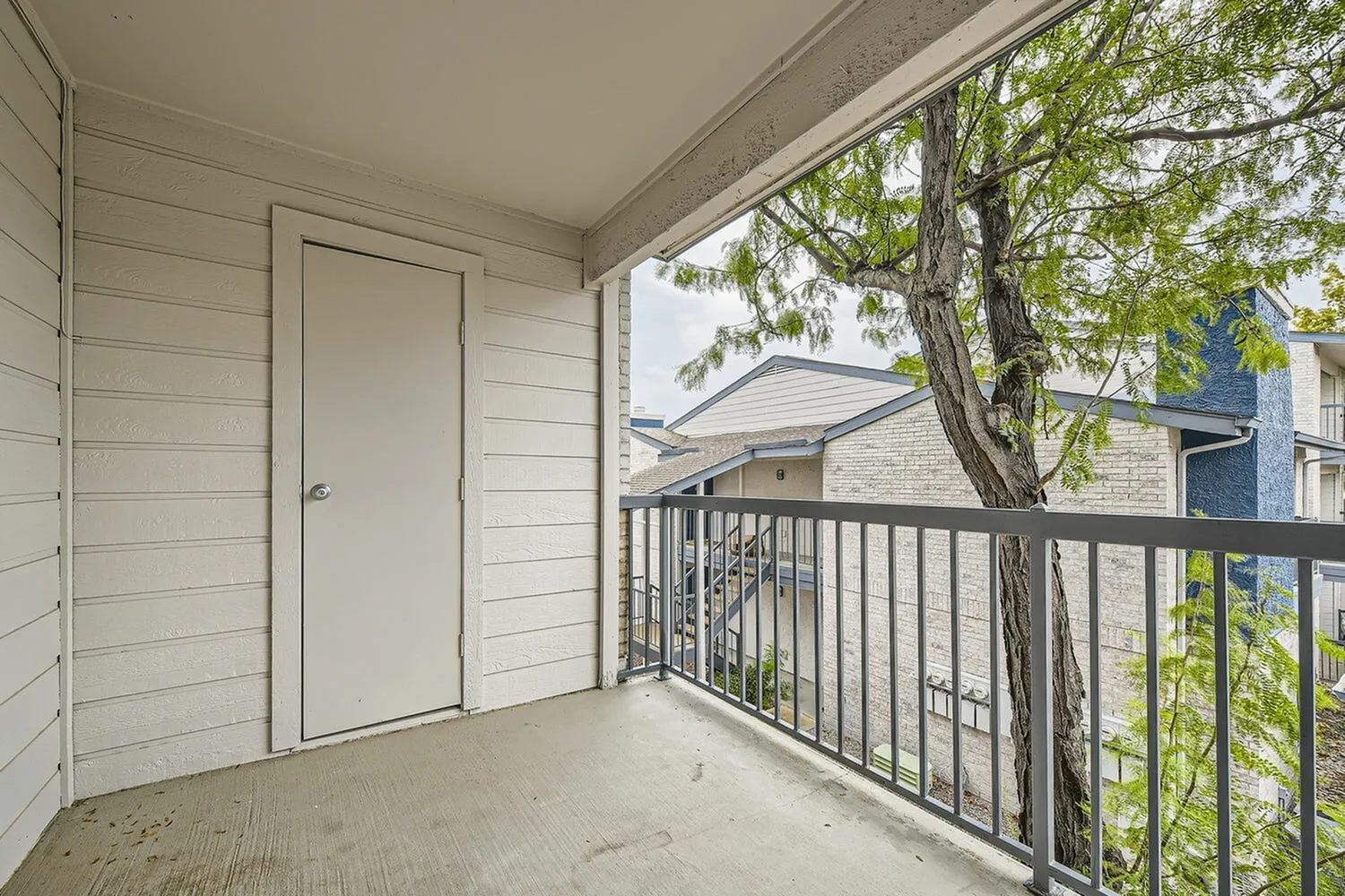 Balcony, metal railing, storage closet door, tree views
