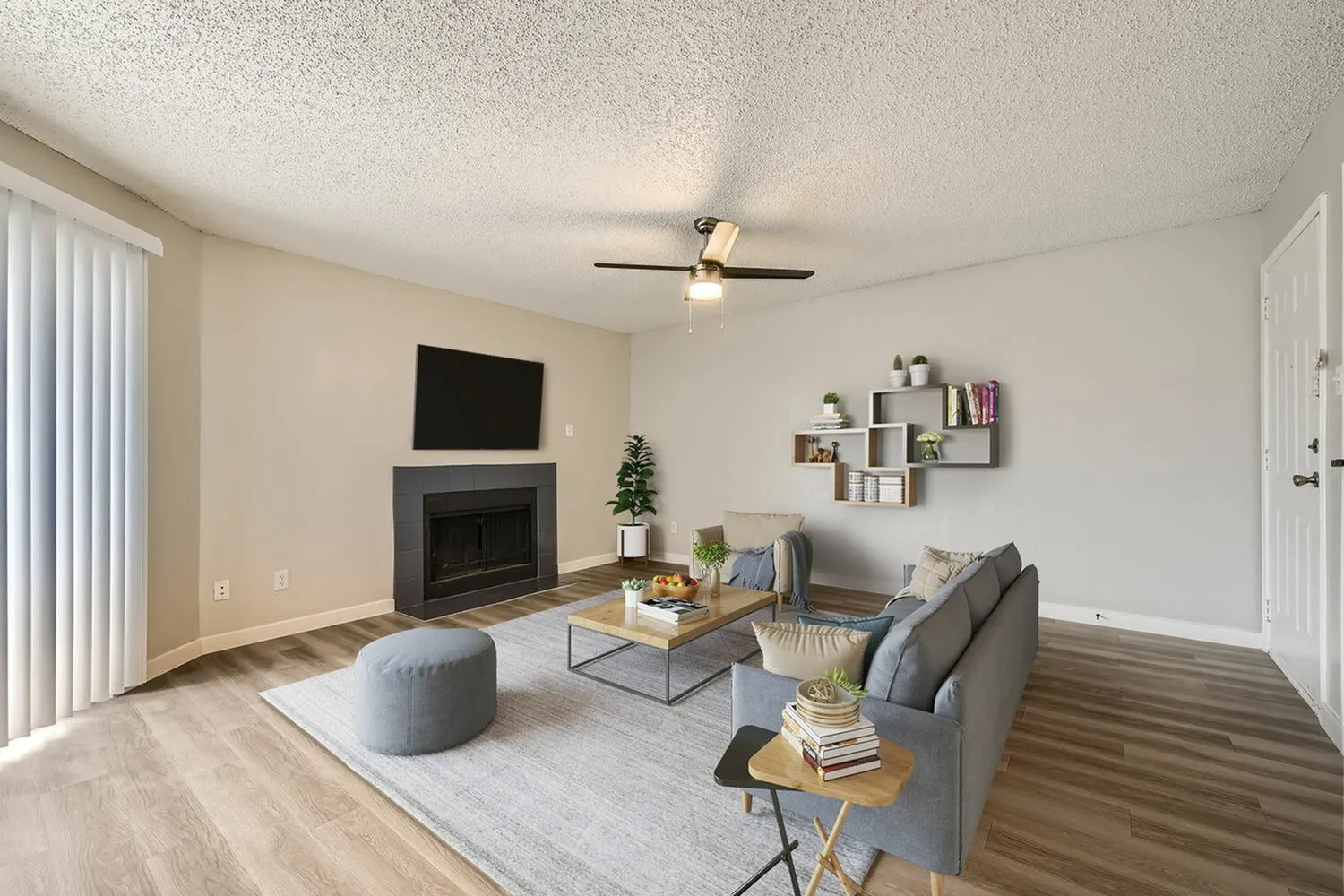 Living room, fireplace, ceiling fan, wood-style plank flooring, open floor plan