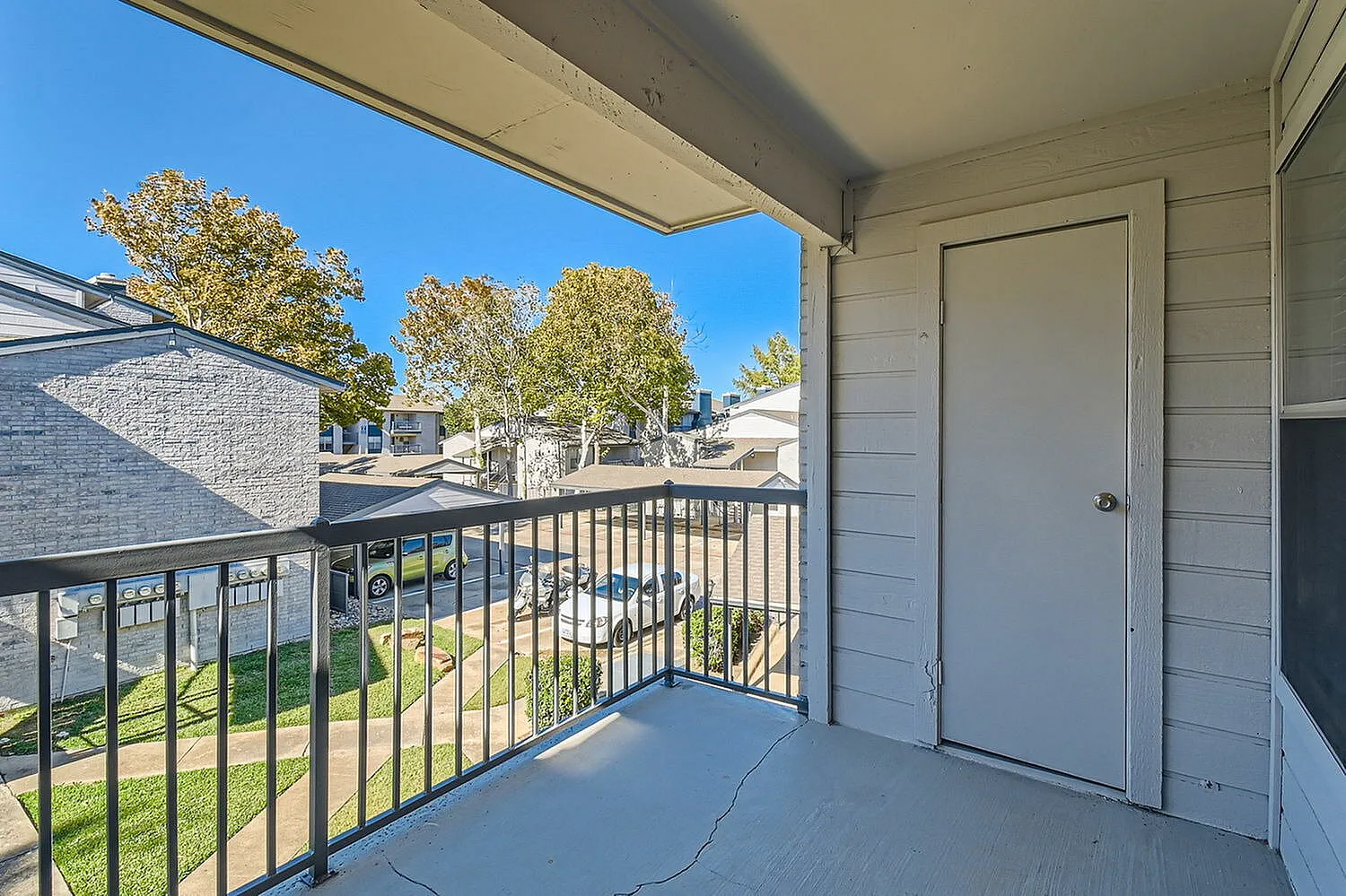 Balcony, metal railing, storage closet door, tree views
